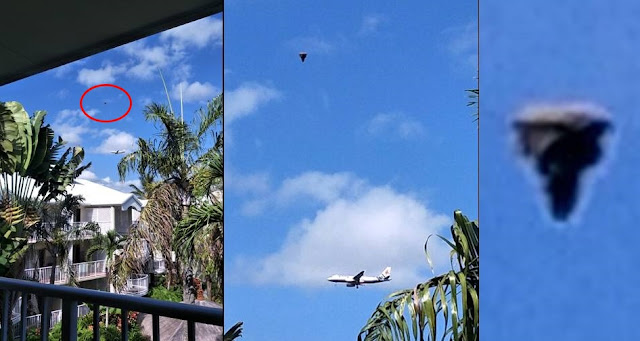 A photographer near Cairns Airport, Australia, captured a flying humanoid above a plane—its eerie silhouette sparking theories of alien surveillance.